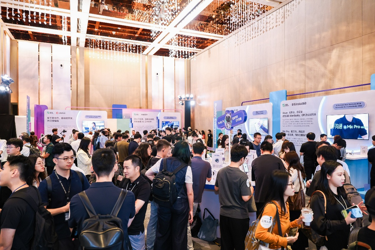 跨境AI智能体相关展会现场,与会者在展台前交流