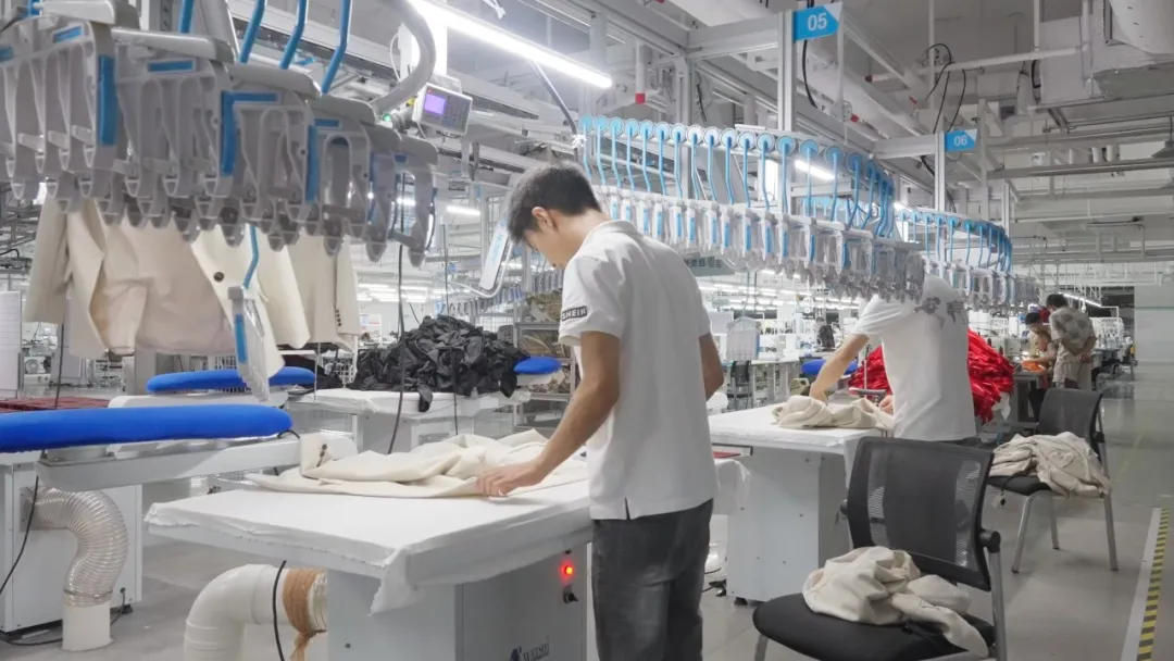 服装工厂吊挂式柔性产线上工人正在作业