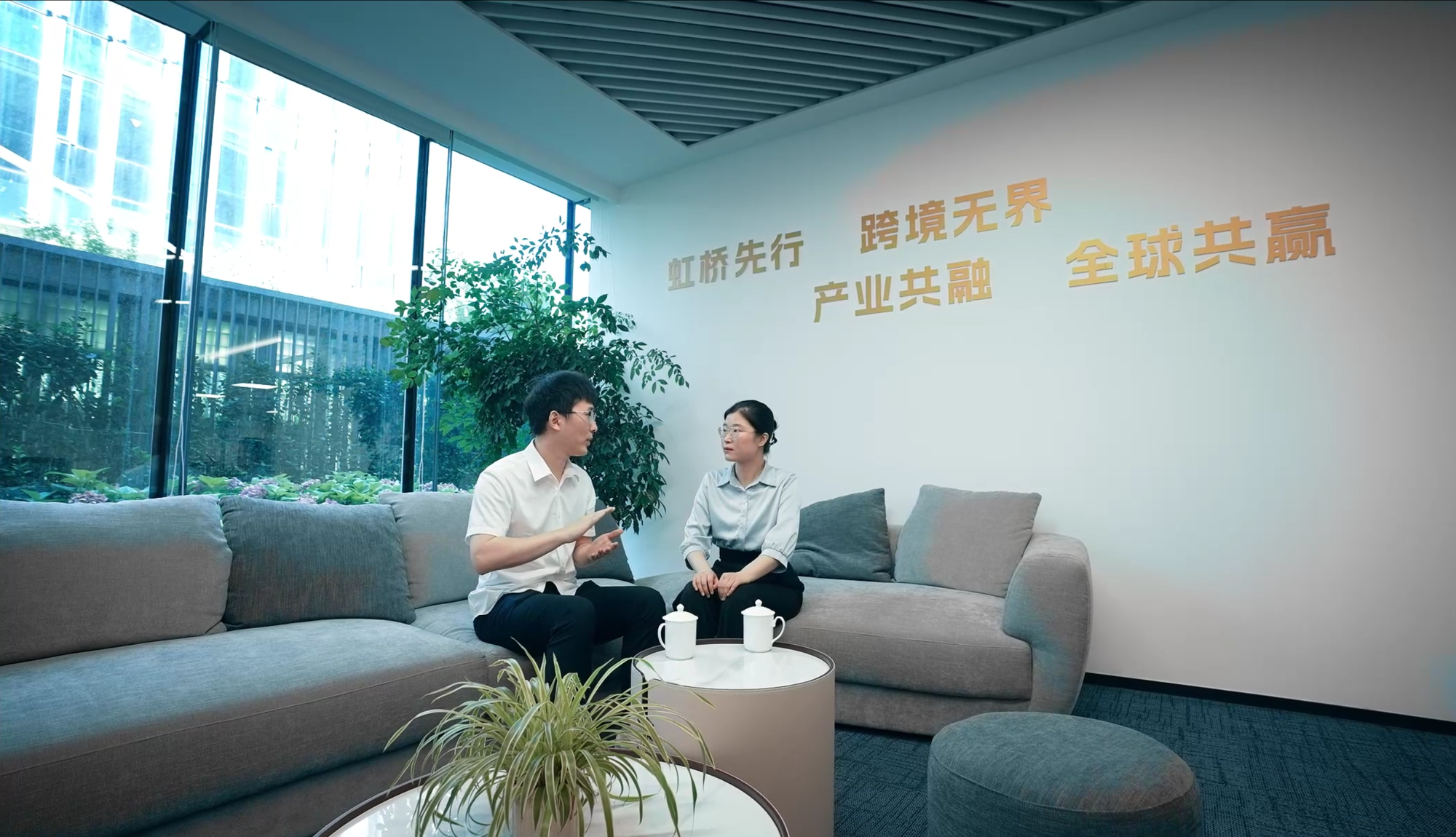虹桥先行区办公空间内人员接受采访,墙面有标语